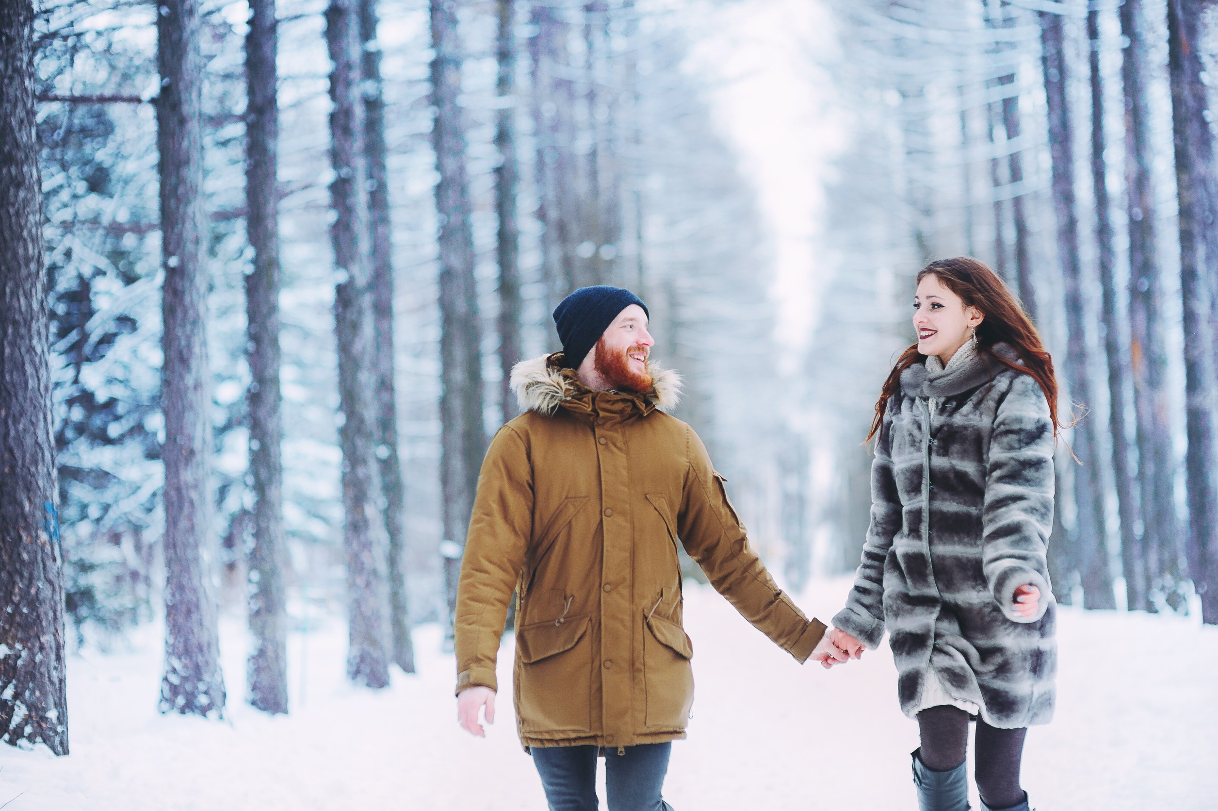 Guy and girl walk ,have fun in the forest in winter