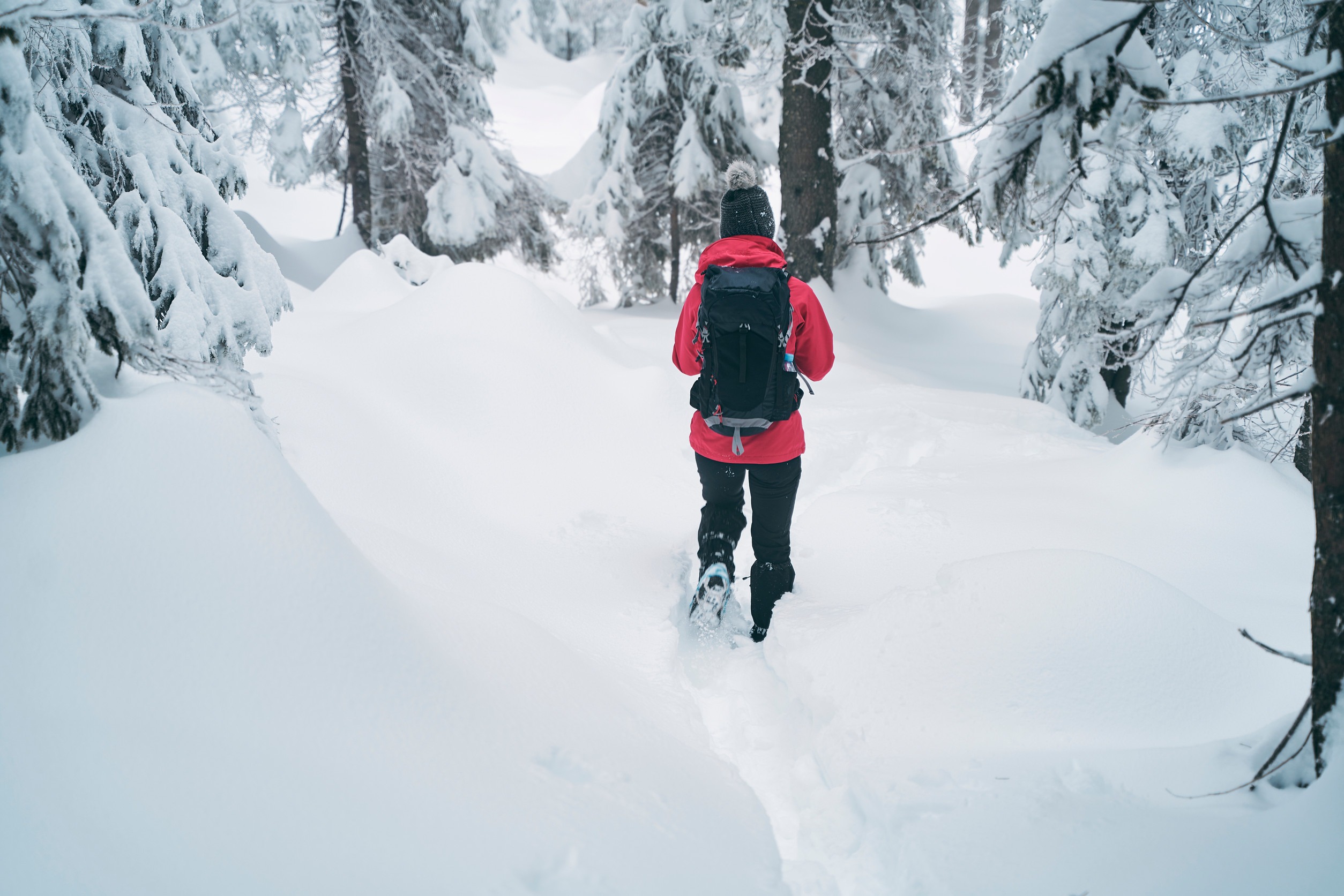 cute young caucasian woman spending her free time hiking outdoors in nature, covered with snow Making a fresh path in newly covered snow